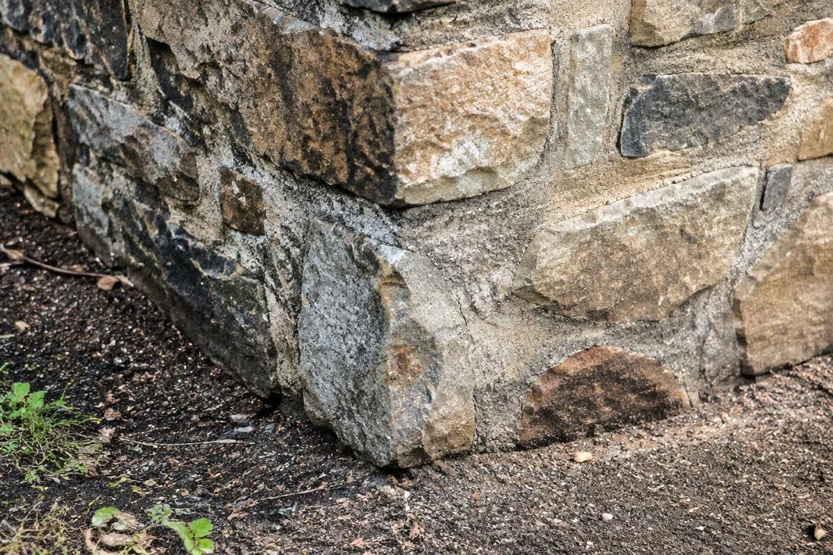 Close-up of a natural stone foundation corner at ground level