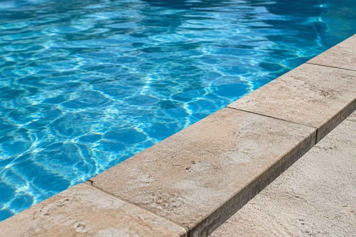 Natural stone pool coping along clear blue water