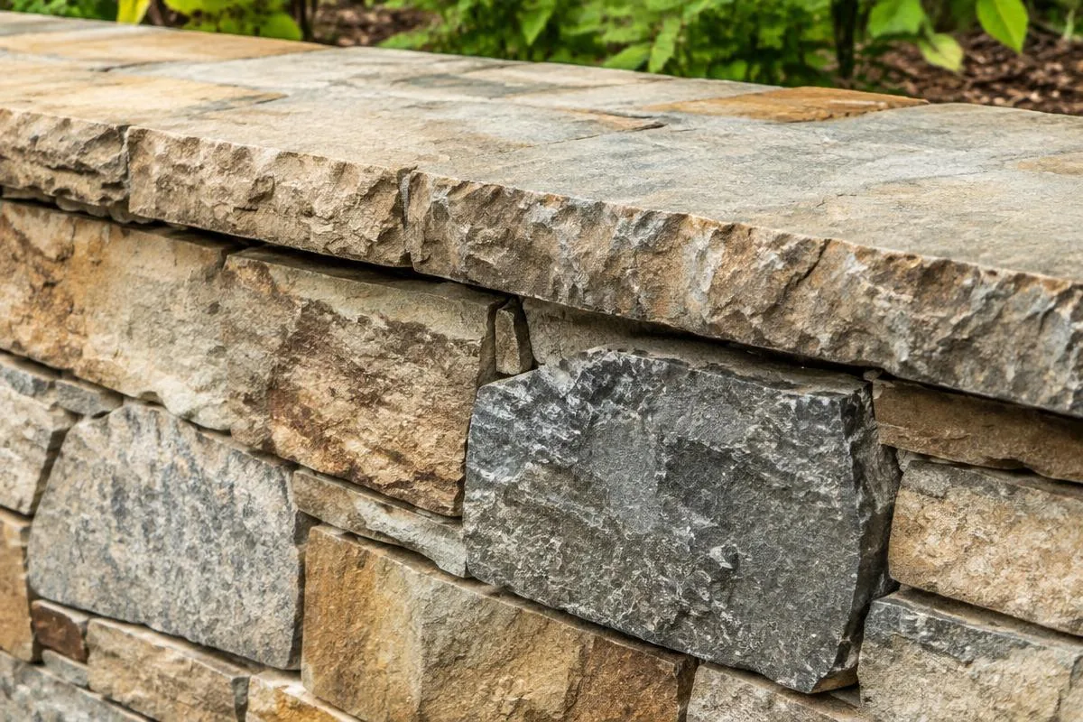 Close-up of a stacked stone retaining wall and cap
